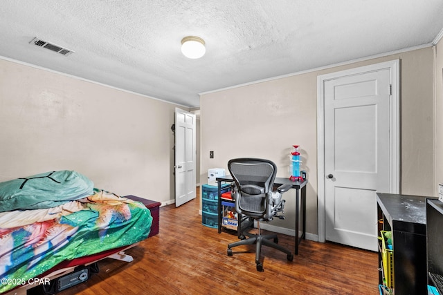 bedroom with dark hardwood / wood-style flooring, ornamental molding, and a textured ceiling