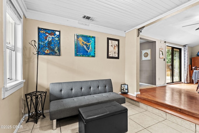 living area with ornamental molding, light tile patterned flooring, and wood ceiling