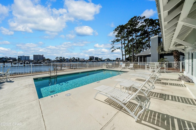 view of pool with a patio and a water view