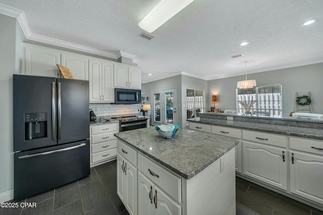 kitchen featuring hanging light fixtures, white cabinetry, electric range, a kitchen island, and black fridge