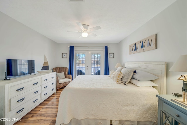 bedroom with ceiling fan, access to exterior, dark hardwood / wood-style floors, and french doors