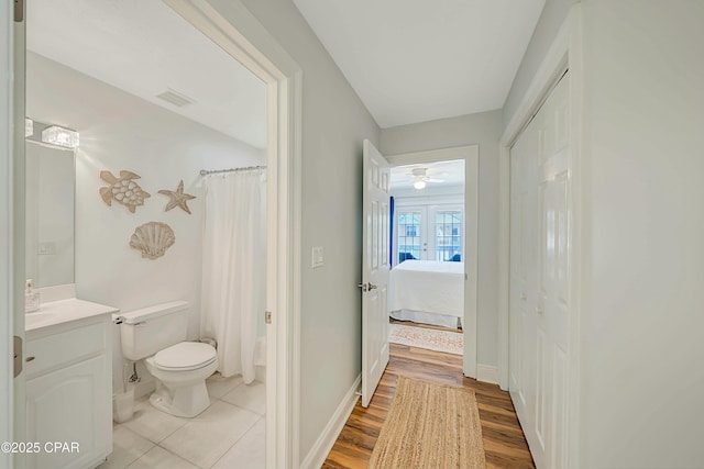 bathroom featuring hardwood / wood-style flooring, toilet, vanity, and ceiling fan