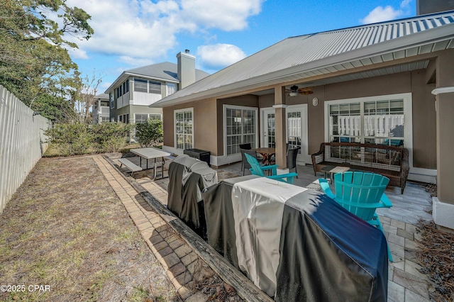 rear view of property with an outdoor living space, ceiling fan, and a patio