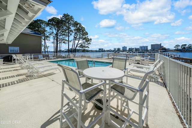 view of swimming pool with a patio and a water view