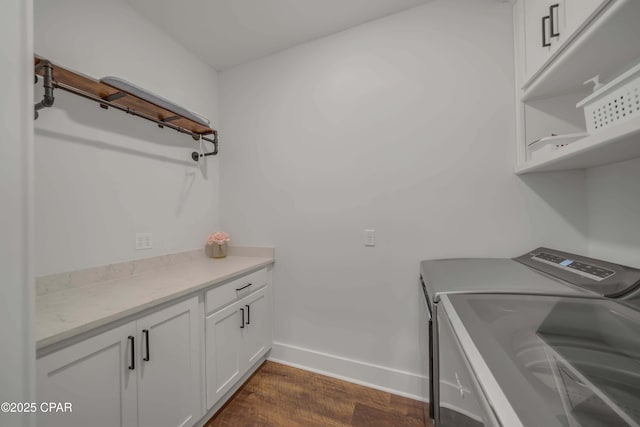 laundry room featuring cabinets, dark hardwood / wood-style flooring, and separate washer and dryer