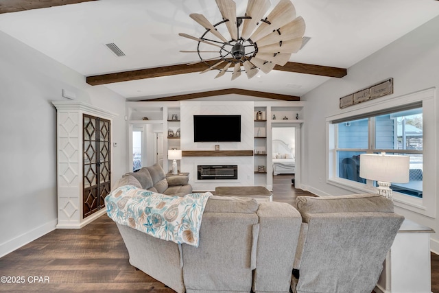 living room with dark hardwood / wood-style floors, vaulted ceiling with beams, built in features, and a high end fireplace