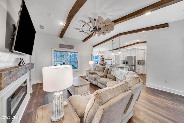 living room with lofted ceiling with beams, ceiling fan, sink, and dark hardwood / wood-style flooring