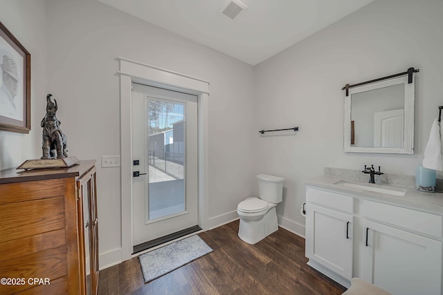 bathroom with wood-type flooring, vanity, and toilet