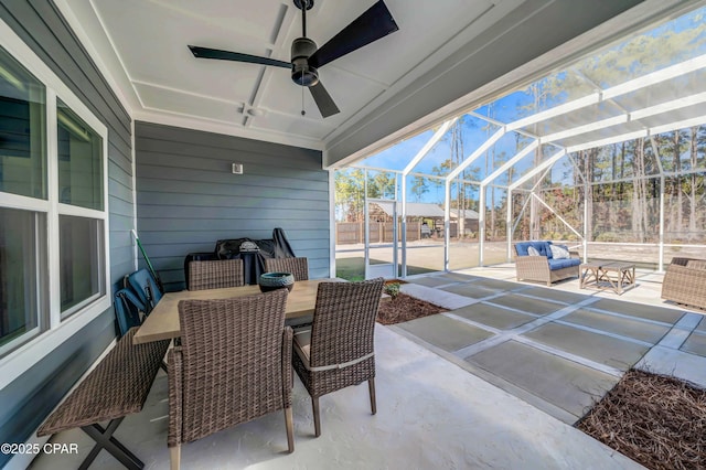 view of patio featuring ceiling fan, outdoor lounge area, and glass enclosure