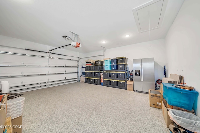 garage with a garage door opener and stainless steel fridge with ice dispenser