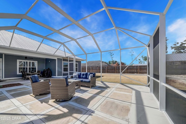 view of patio featuring ceiling fan, an outdoor hangout area, and glass enclosure