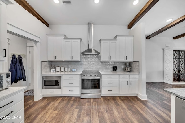 kitchen featuring wall chimney exhaust hood, appliances with stainless steel finishes, decorative backsplash, and white cabinets