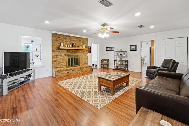 living room with ceiling fan, hardwood / wood-style floors, and a fireplace