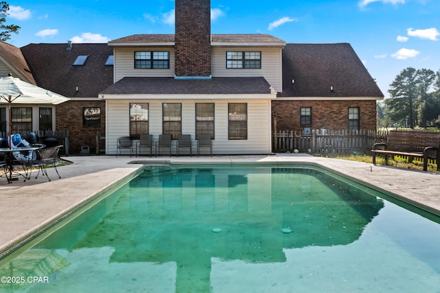 back of house featuring a fenced in pool and a patio