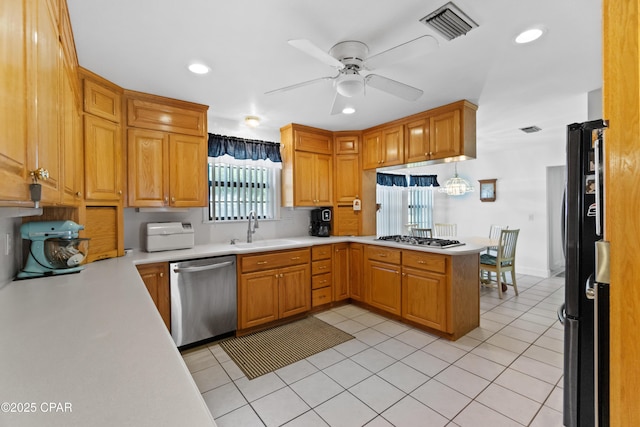 kitchen featuring kitchen peninsula, ceiling fan, appliances with stainless steel finishes, sink, and light tile patterned floors