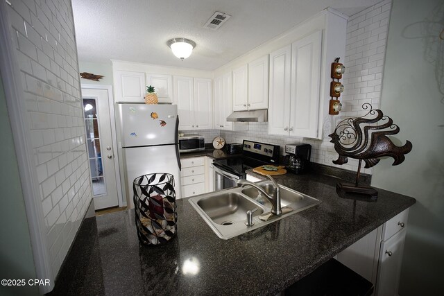 kitchen featuring appliances with stainless steel finishes, white cabinetry, decorative backsplash, sink, and kitchen peninsula