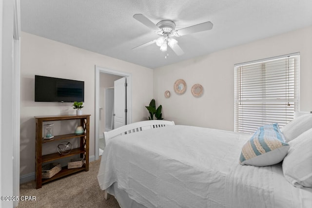 bedroom featuring ceiling fan, light colored carpet, and a textured ceiling