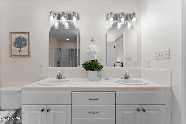 bathroom with walk in shower, vanity, and toilet