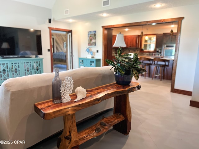 living area with baseboards, visible vents, recessed lighting, and vaulted ceiling