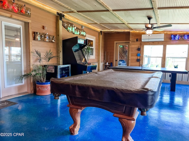 recreation room with wooden walls, billiards, ceiling fan, and finished concrete floors