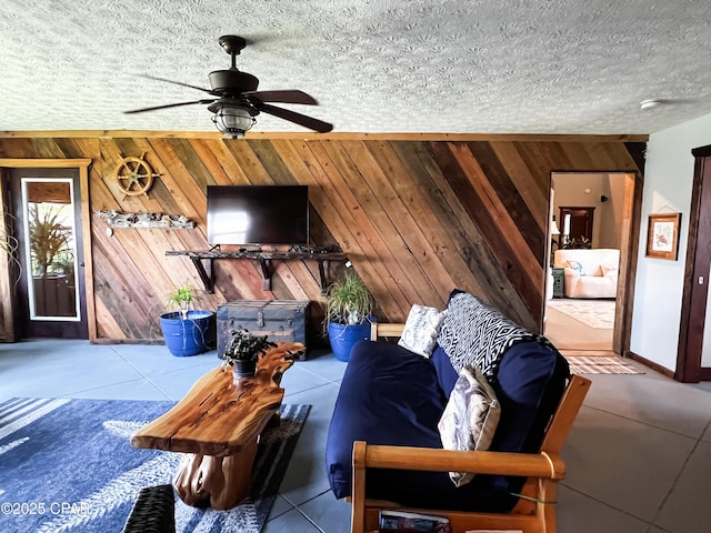 living area with wood walls and a ceiling fan