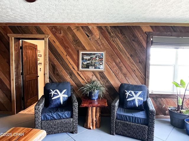 sitting room featuring tile patterned floors and wood walls
