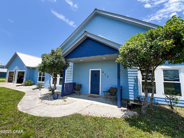 rear view of house featuring a porch and a yard