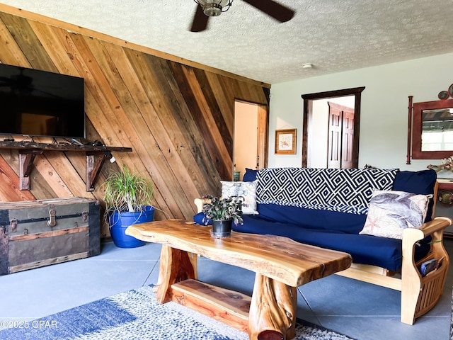 living room featuring ceiling fan and wood walls