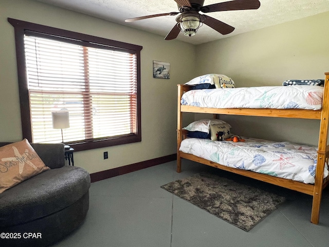 bedroom with a textured ceiling, baseboards, a ceiling fan, and multiple windows
