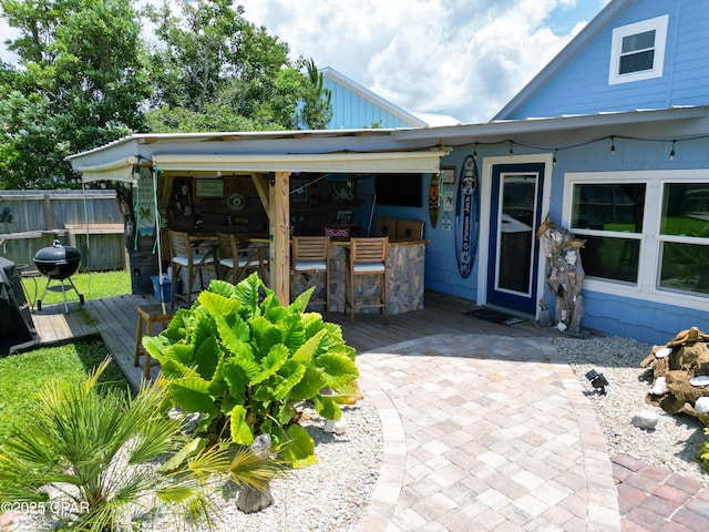 view of patio / terrace with outdoor dry bar, a deck, and fence