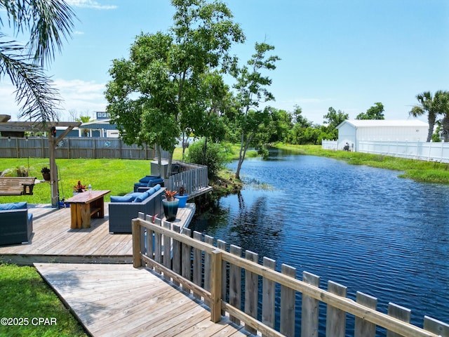 dock area with fence, a deck with water view, a yard, and an outdoor living space