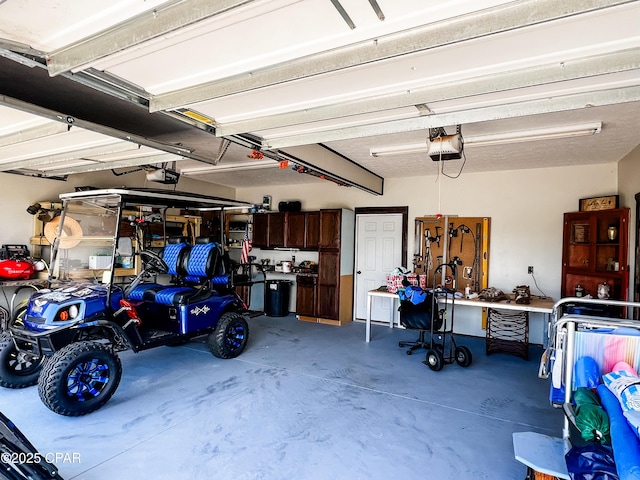 garage with a workshop area and a garage door opener