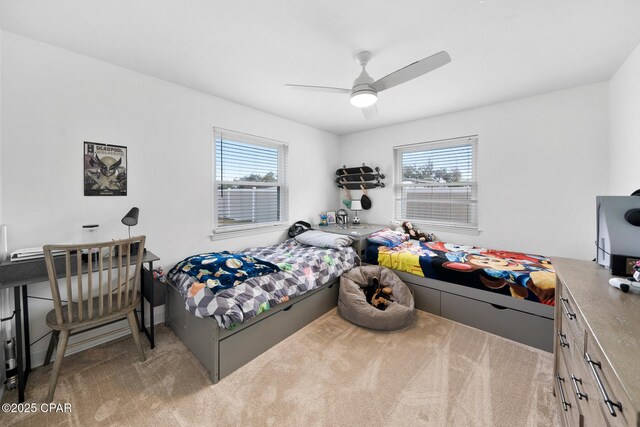 bedroom with ceiling fan, light colored carpet, and multiple windows