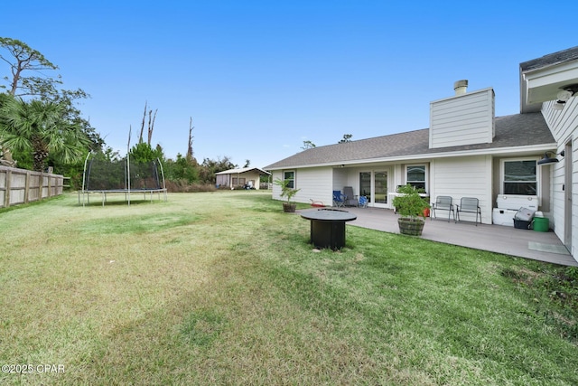 view of yard with an outdoor fire pit, a patio, and a trampoline