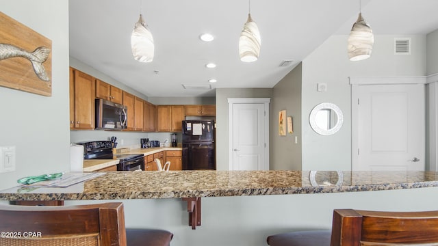 kitchen with decorative light fixtures, a kitchen bar, kitchen peninsula, and black appliances