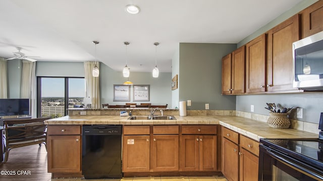 kitchen with kitchen peninsula, ceiling fan, black appliances, pendant lighting, and sink