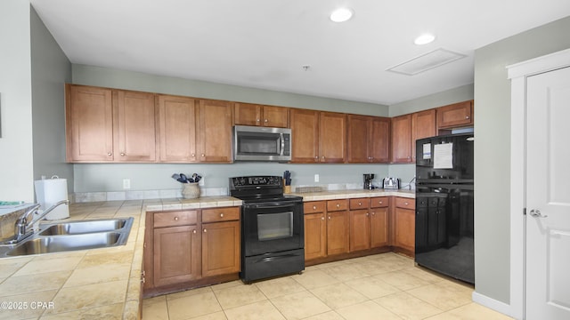 kitchen with sink, black appliances, and tile counters