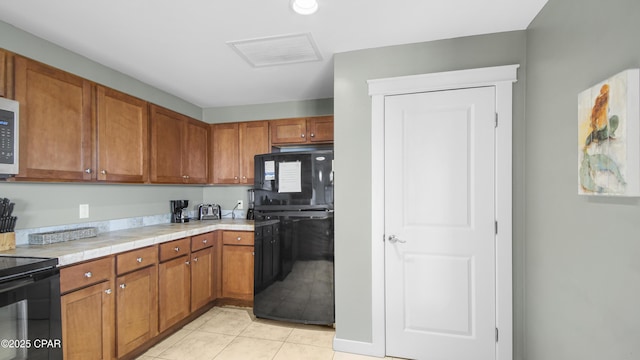 kitchen featuring light tile patterned floors, black appliances, and tile countertops