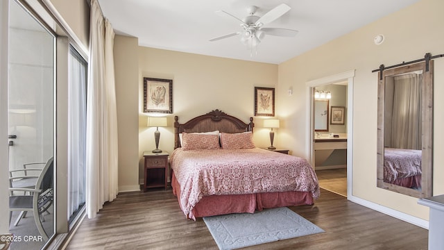 bedroom featuring ceiling fan, connected bathroom, dark hardwood / wood-style floors, and a barn door