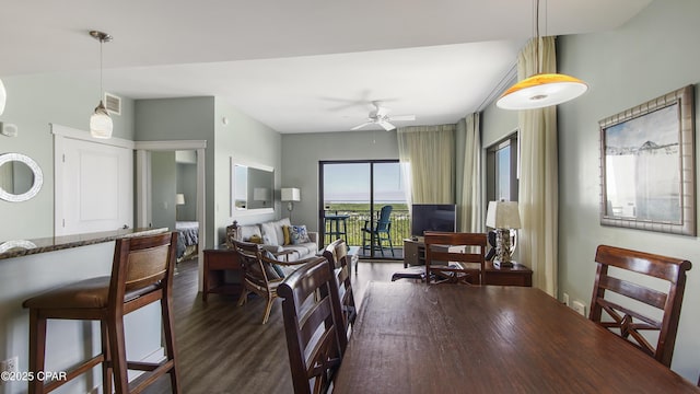 dining space with ceiling fan and dark hardwood / wood-style flooring