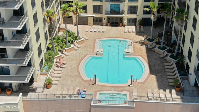 view of swimming pool with a hot tub