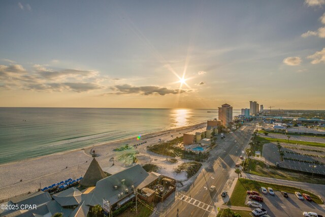 aerial view at dusk with a beach view and a water view