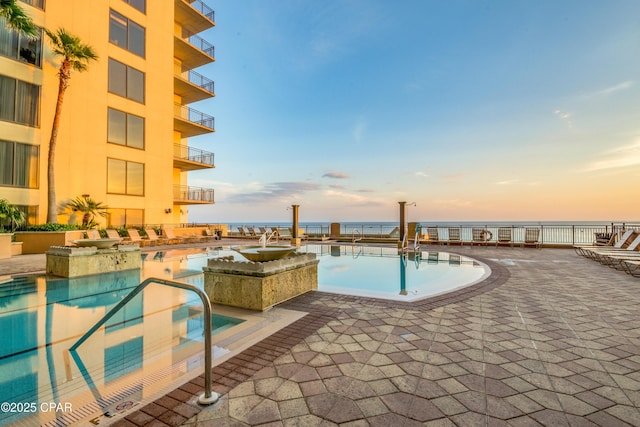 view of pool at dusk