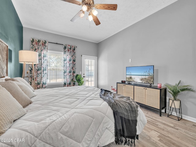 bedroom with crown molding, ceiling fan, a textured ceiling, light wood-type flooring, and baseboards