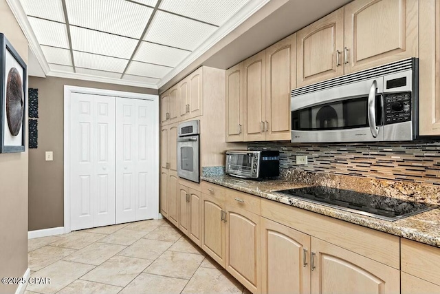 kitchen featuring a toaster, light brown cabinets, appliances with stainless steel finishes, and tasteful backsplash