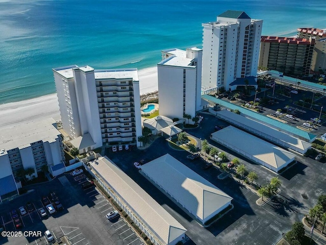 birds eye view of property featuring a beach view and a water view