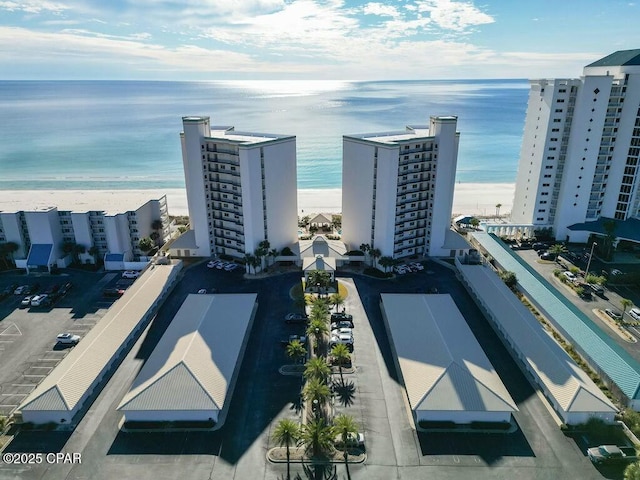 bird's eye view featuring a water view and a beach view