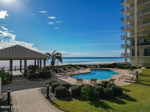 pool with a gazebo, a patio area, and a water view