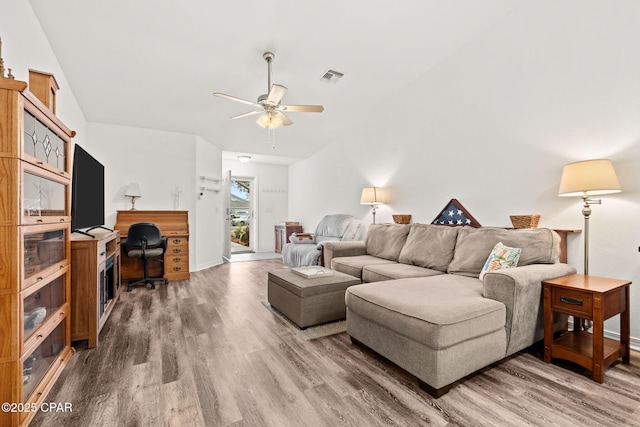 living room with hardwood / wood-style flooring, vaulted ceiling, and ceiling fan