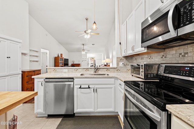 kitchen with white cabinetry, stainless steel appliances, kitchen peninsula, and sink
